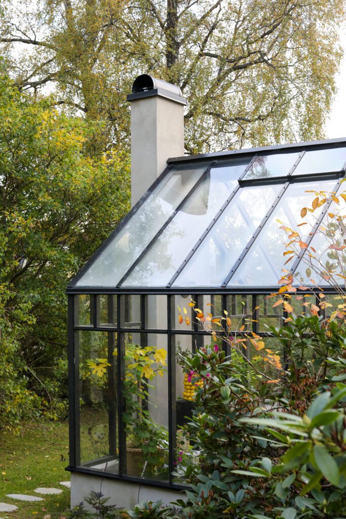 En kamin inne i växthuset gör att ett växthus kan användas även under den kalla årstiden. Här är det växthuset Astrid i serien Ulrika Levin edition som visas.